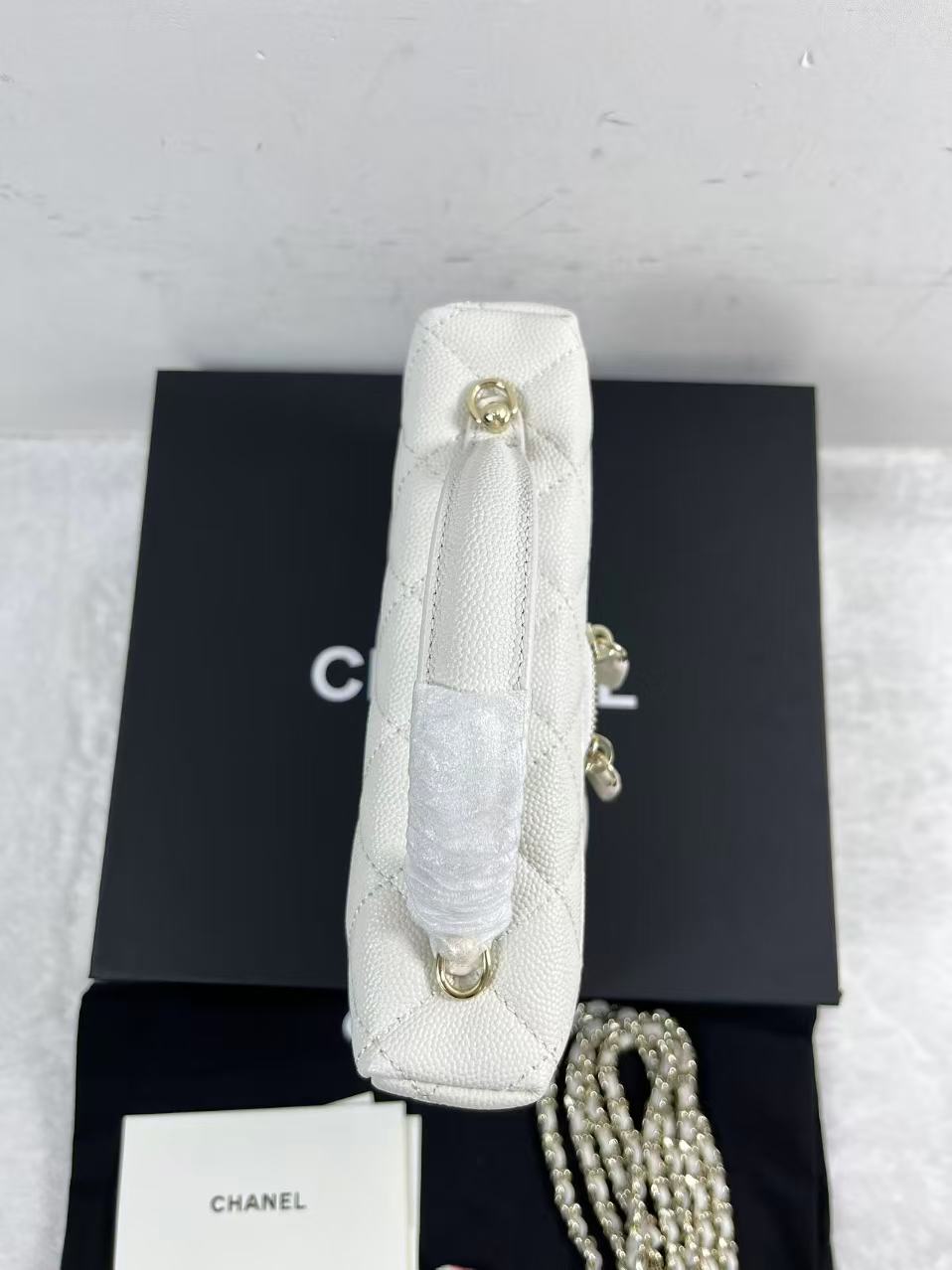 Chanel vanity case likely crafted from white quilted caviar leather featuring gold-tone hardware