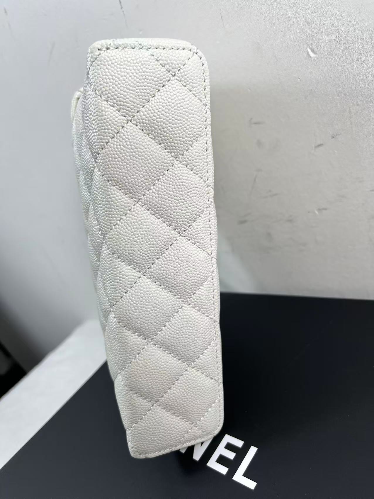Chanel vanity case likely crafted from white quilted caviar leather featuring gold-tone hardware