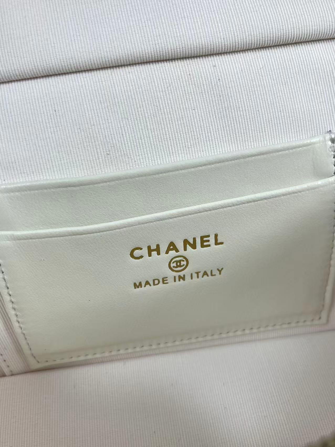 Chanel vanity case likely crafted from white quilted caviar leather featuring gold-tone hardware