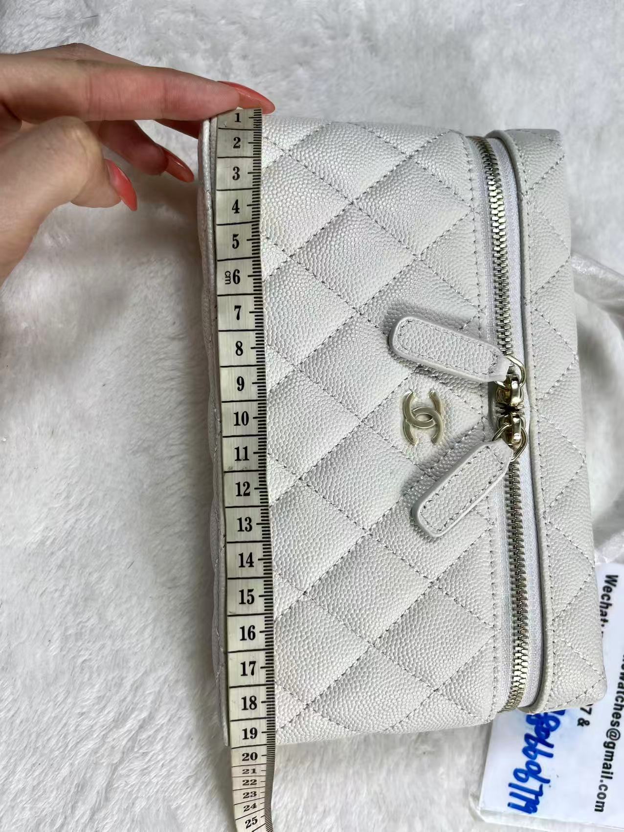 Chanel vanity case likely crafted from white quilted caviar leather featuring gold-tone hardware