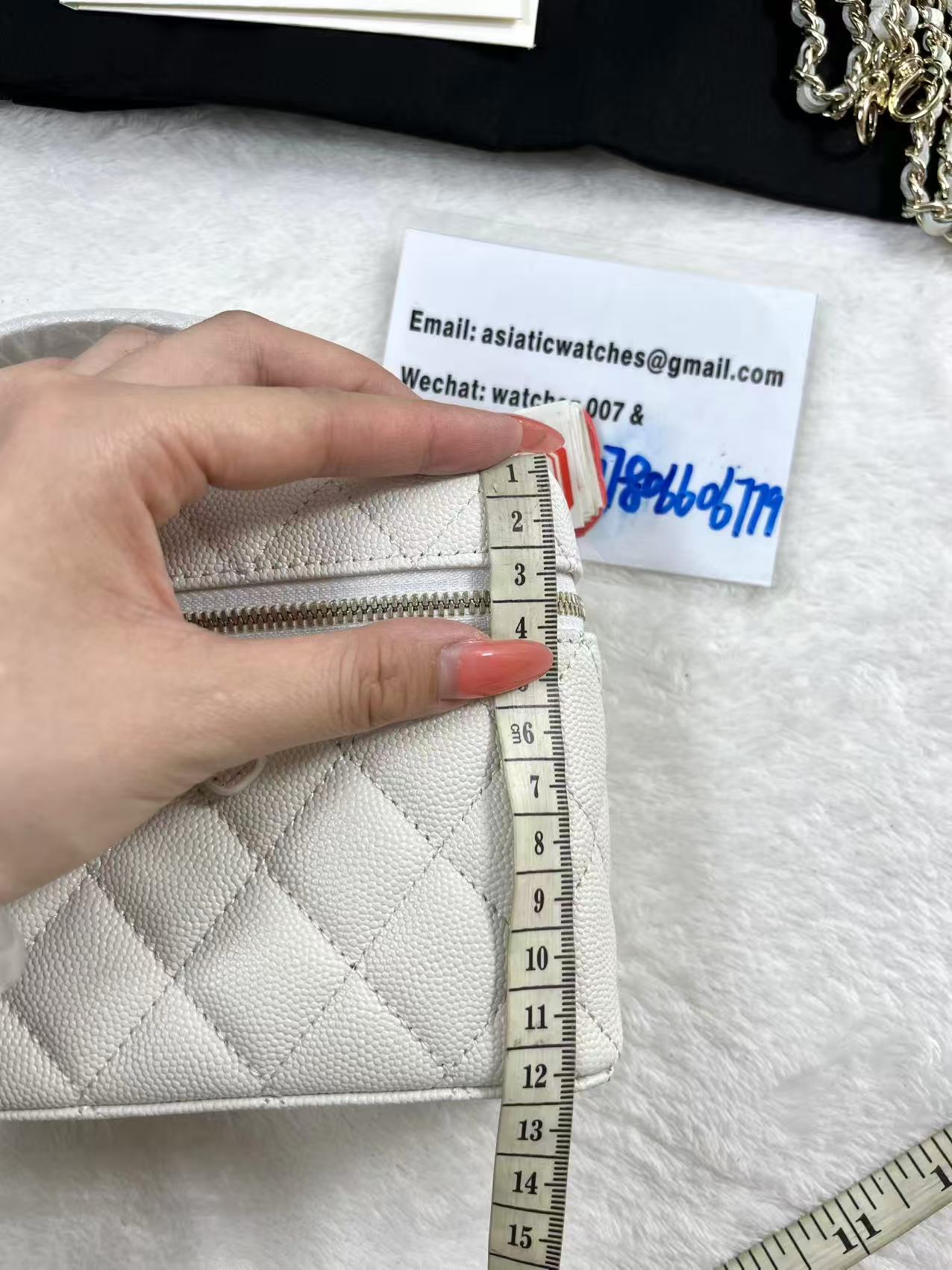 Chanel vanity case likely crafted from white quilted caviar leather featuring gold-tone hardware