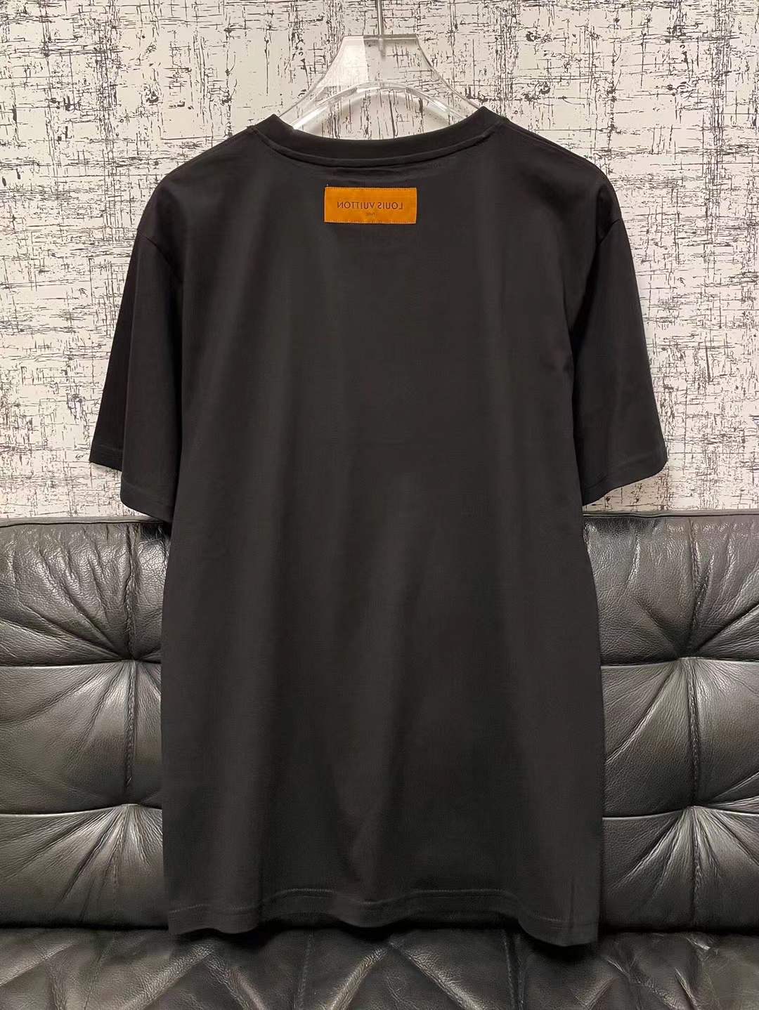 LV t-shirt features a distinctive green and black checkered graphic print resembling one of the brand's iconic handbags