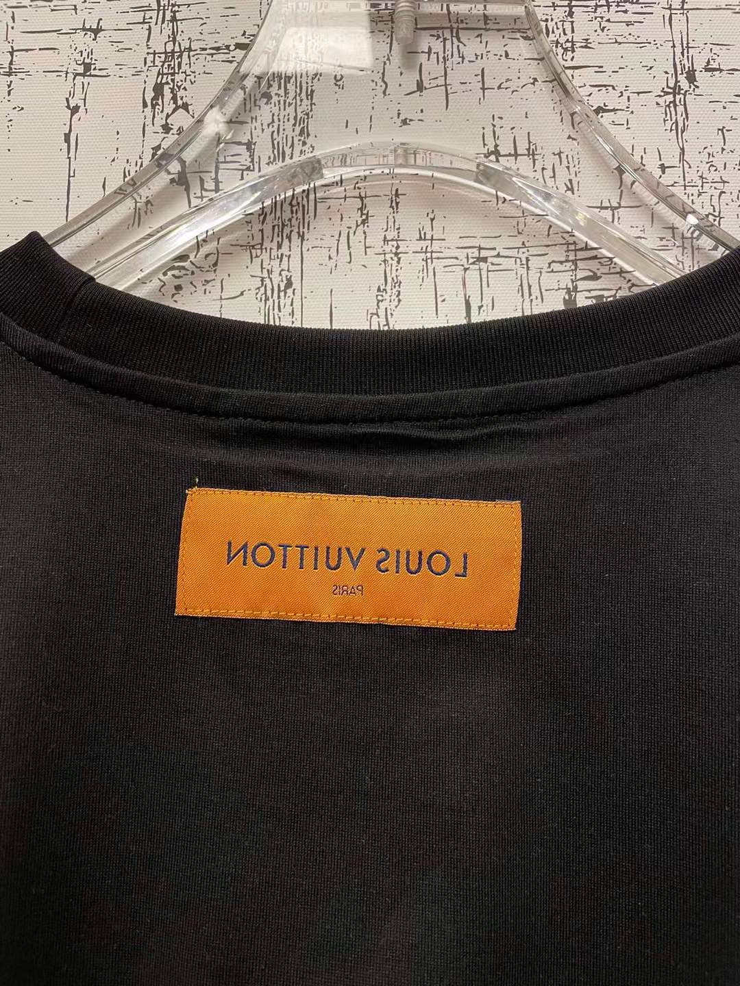 LV t-shirt features a distinctive green and black checkered graphic print resembling one of the brand's iconic handbags