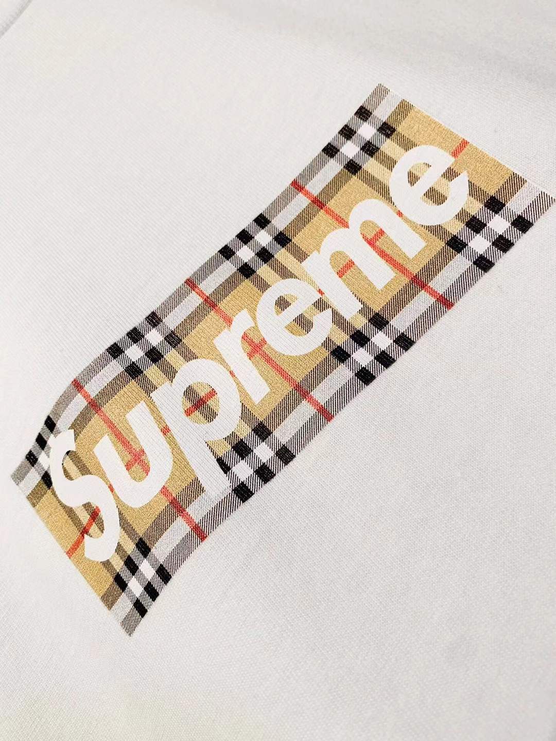 Supreme x Burberry Box Logo Tee in White from the Spring/Summer 2022 collection, which features a plaid design on the box logo