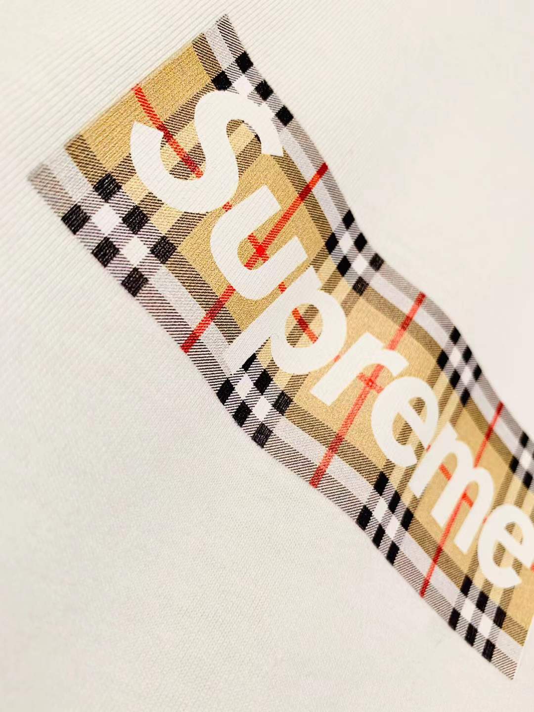 Supreme x Burberry Box Logo Tee in White from the Spring/Summer 2022 collection, which features a plaid design on the box logo