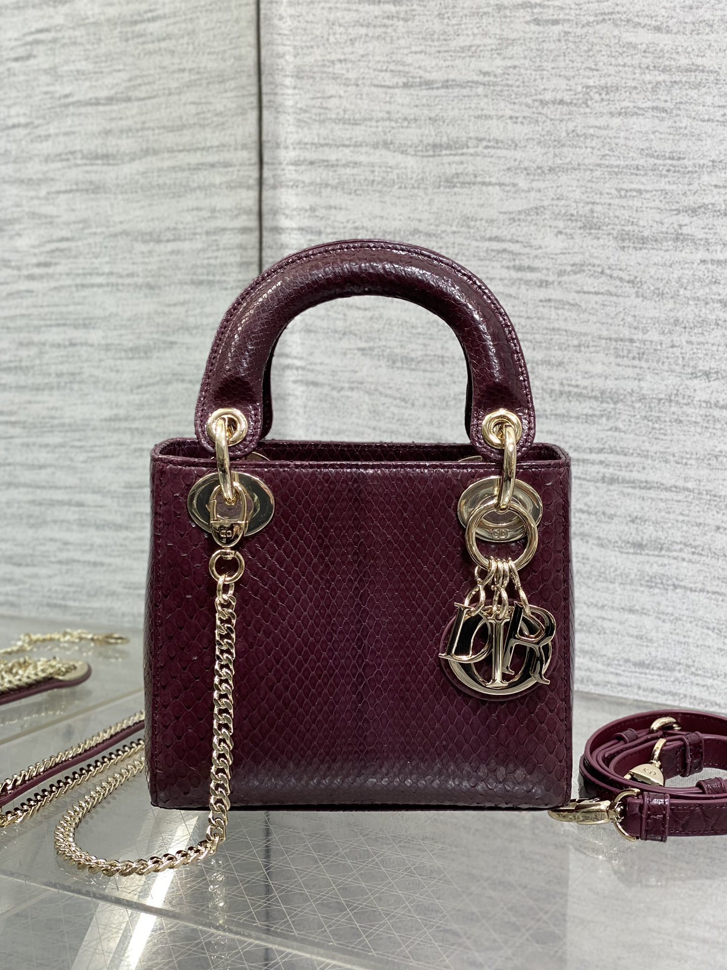 Christian Dior burgundy python leather Mini Lady Dior bag featuring gold-tone hardware and signature charms