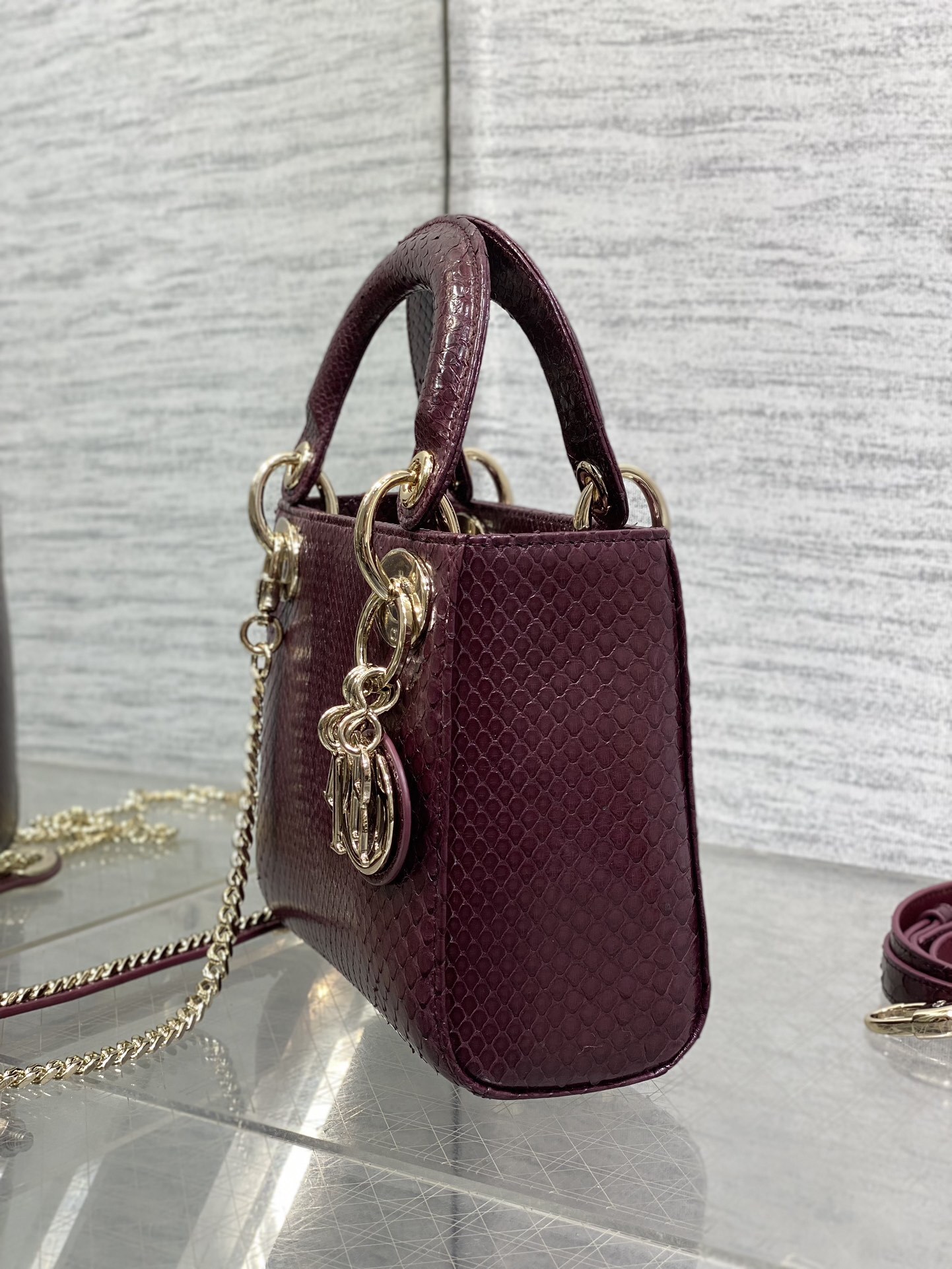 Christian Dior burgundy python leather Mini Lady Dior bag featuring gold-tone hardware and signature charms