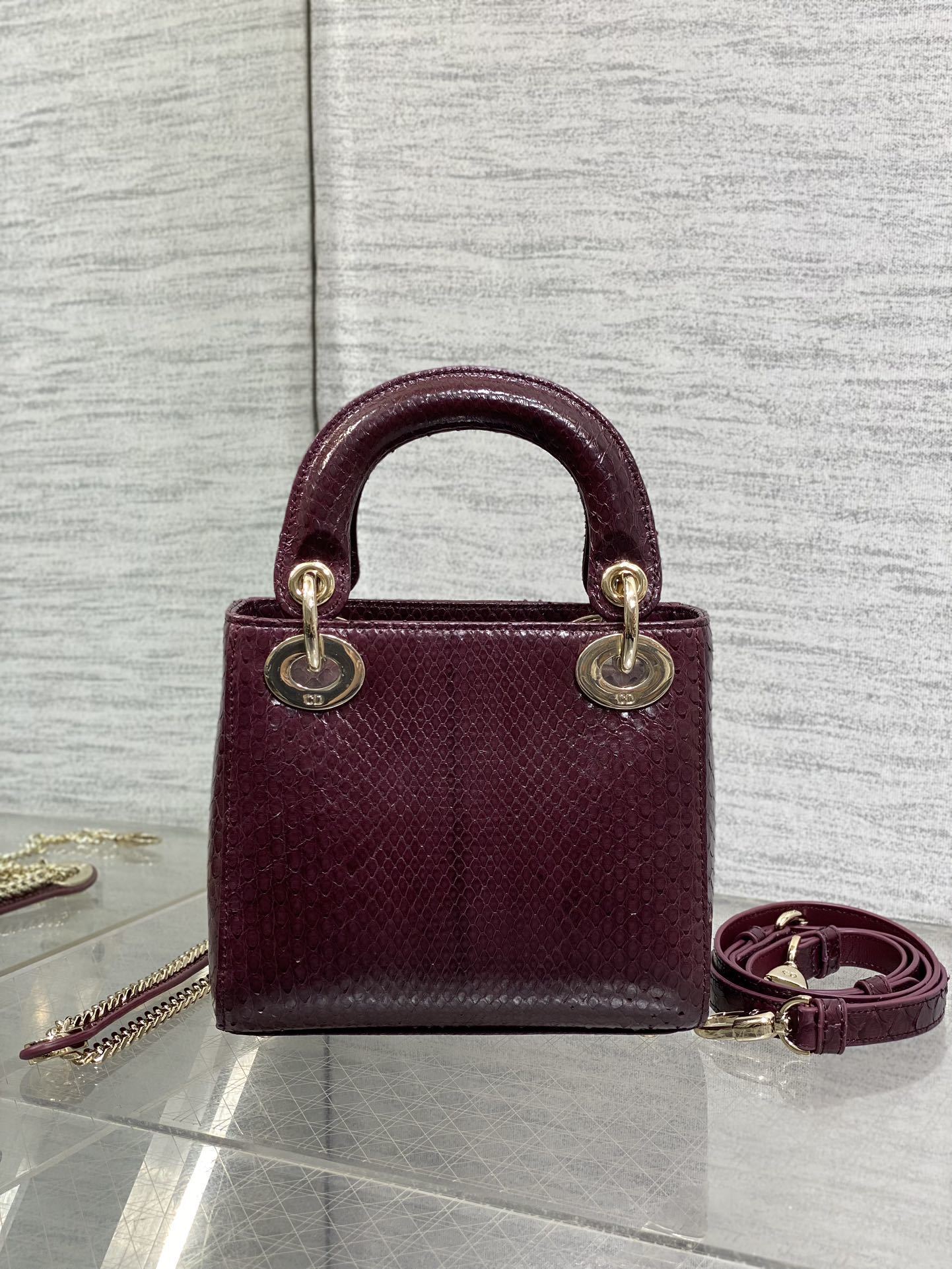 Christian Dior burgundy python leather Mini Lady Dior bag featuring gold-tone hardware and signature charms