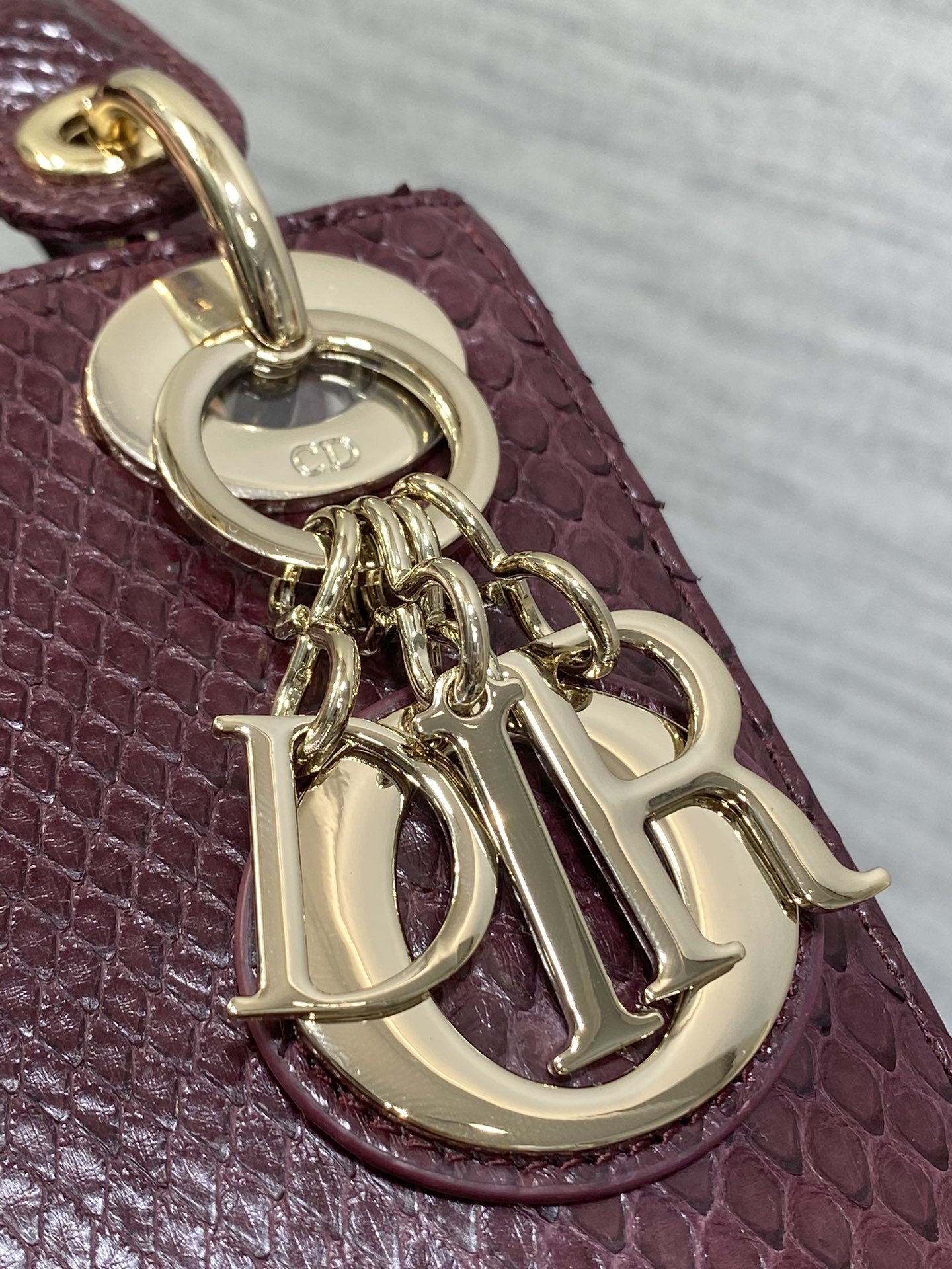 Christian Dior burgundy python leather Mini Lady Dior bag featuring gold-tone hardware and signature charms