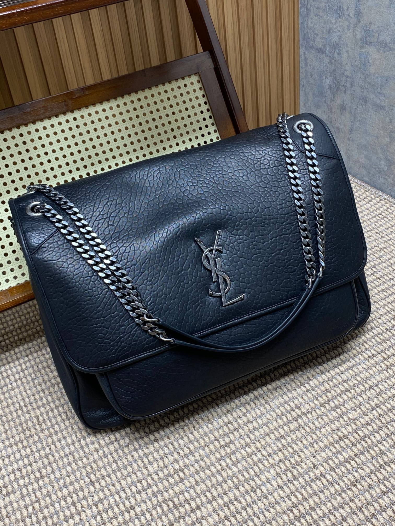 Saint Laurent Niki shoulder bag recognized by its crinkled leather, YSL emblem, and chain strap.