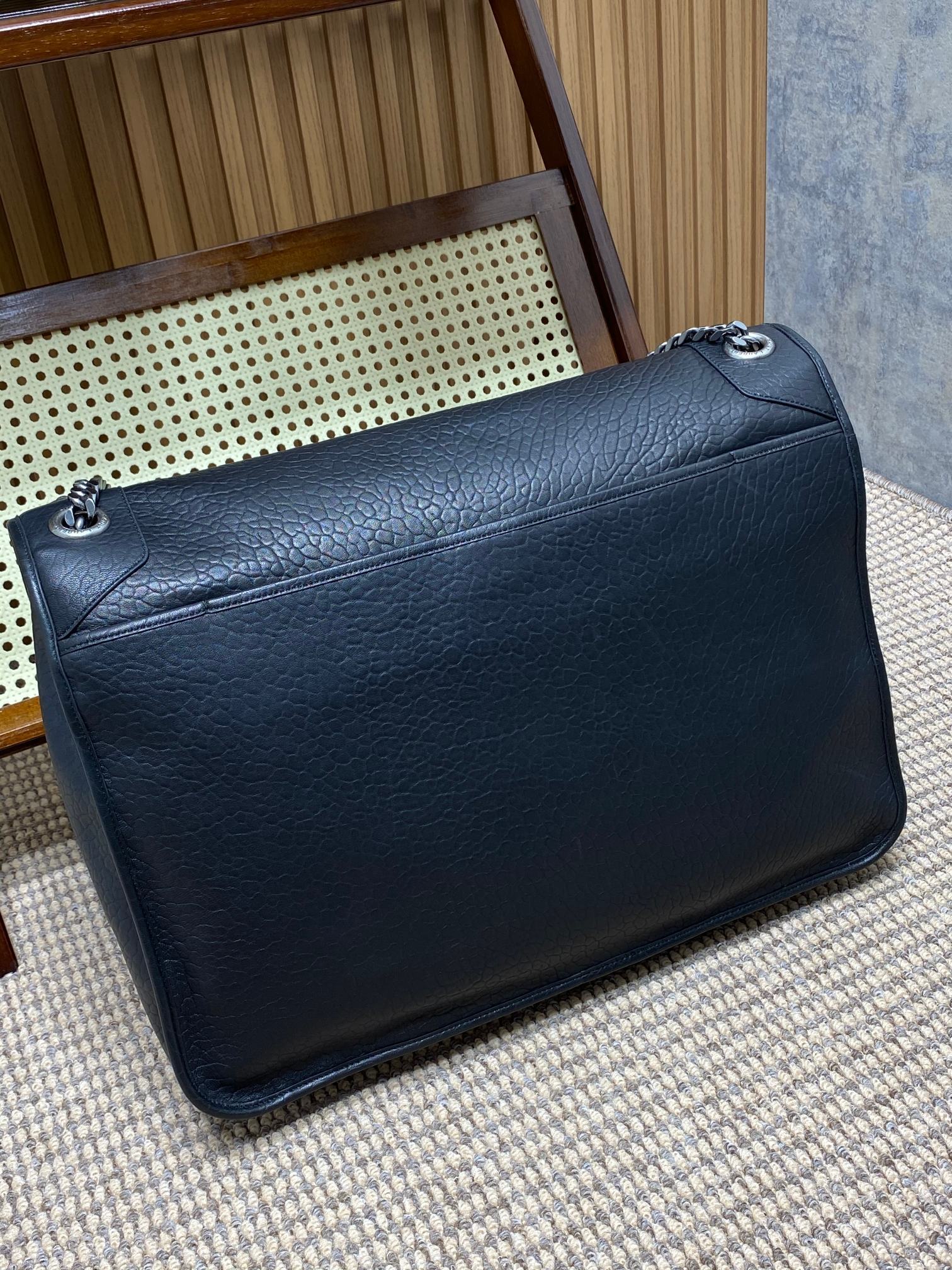 Saint Laurent Niki shoulder bag recognized by its crinkled leather, YSL emblem, and chain strap.