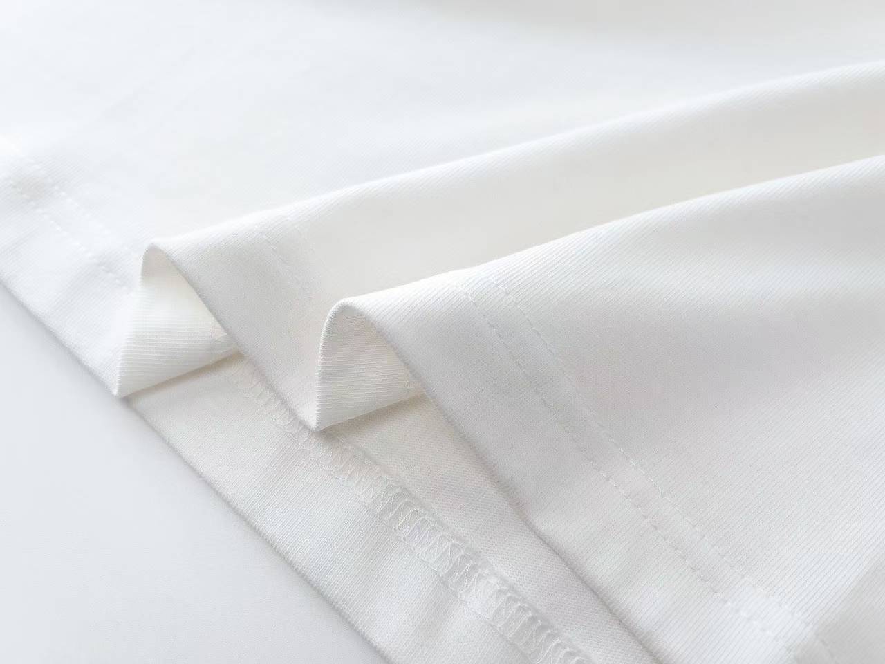 Burberry Label Appliqué Cotton Oversized T-Shirt is a white cotton t-shirt featuring a distinctive woven patch inspired by signature trench coat labels.