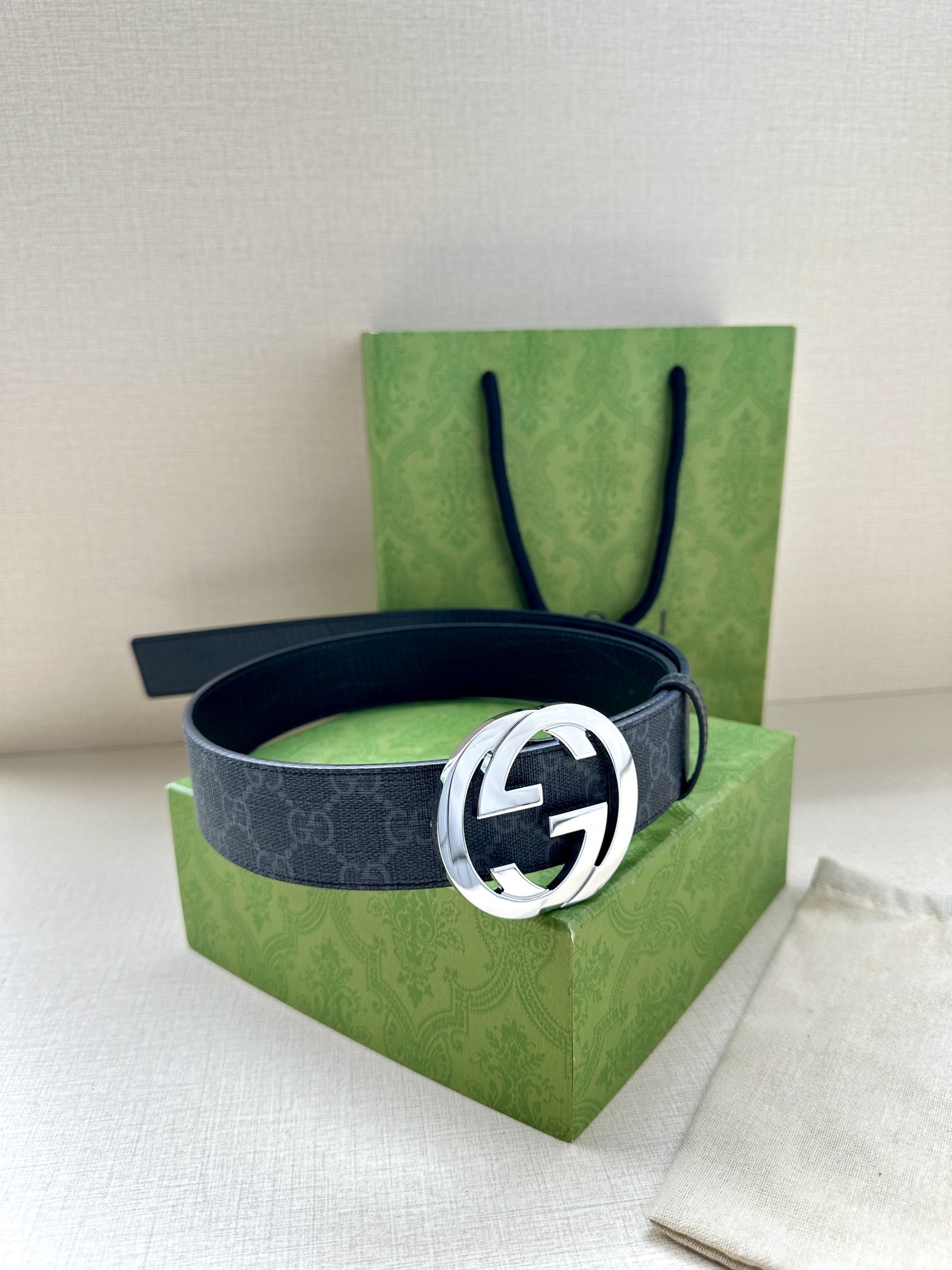 Gucci belt is a Black/Grey GG Supreme canvas belt featuring a signature silver-tone Interlocking G buckle