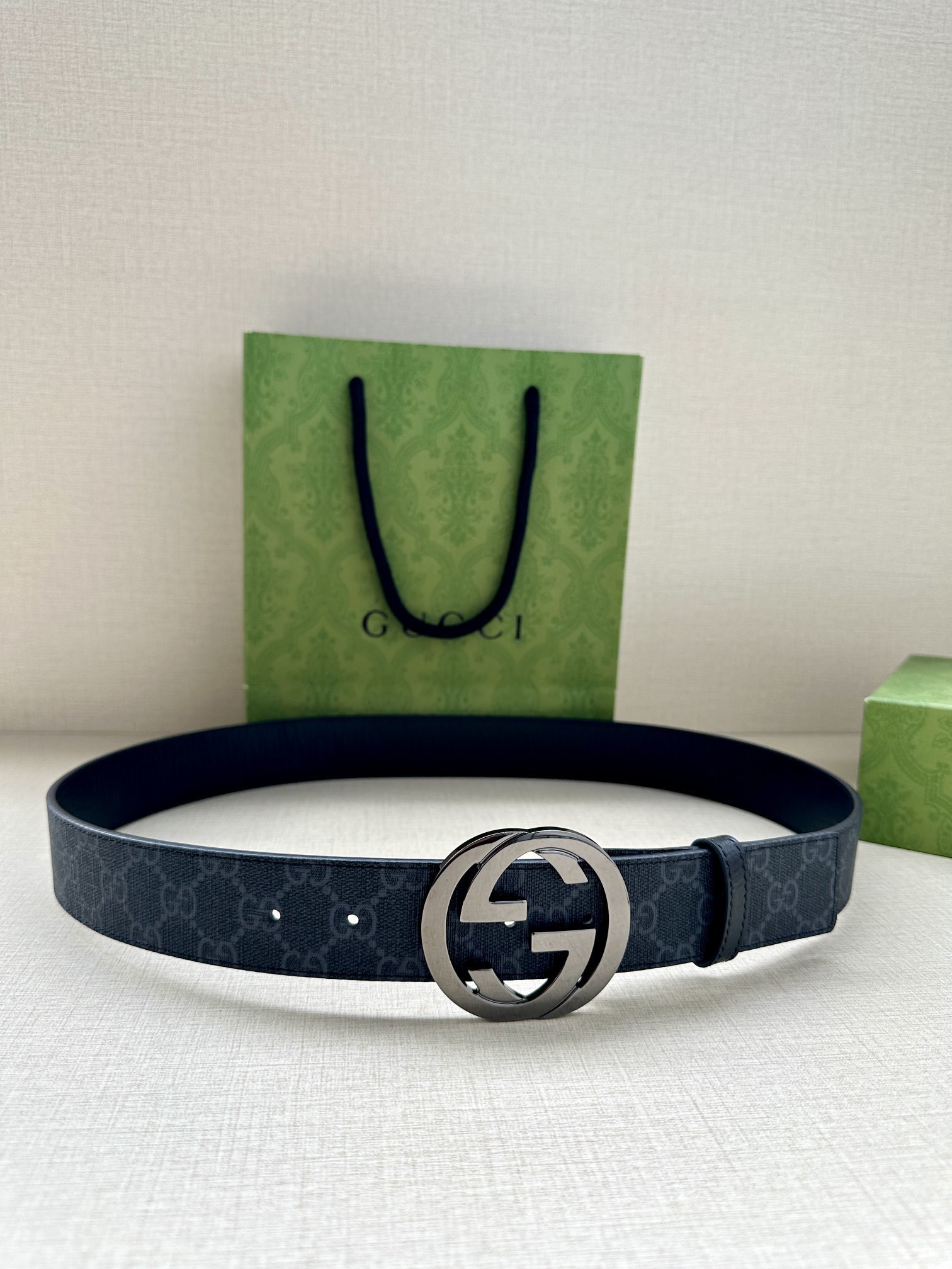 Gucci belt is a Black/Grey GG Supreme canvas belt featuring a signature silver-tone Interlocking G buckle