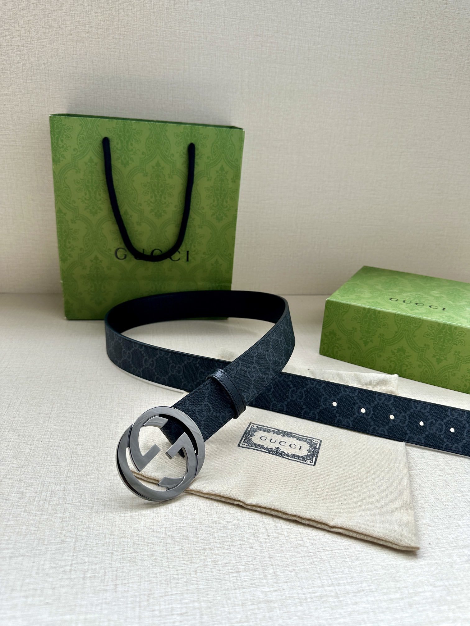 Gucci belt is a Black/Grey GG Supreme canvas belt featuring a signature silver-tone Interlocking G buckle