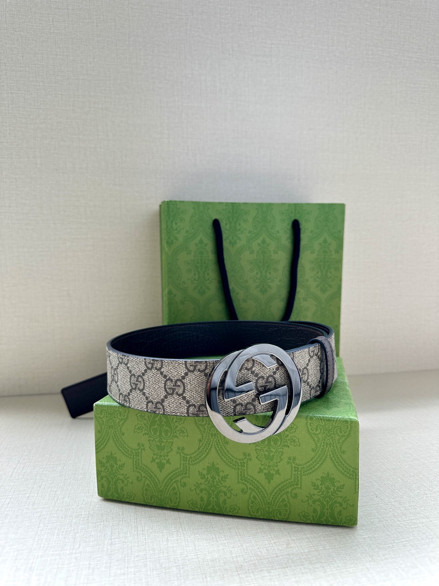 Gucci GG Marmont reversible belt featuring a beige and ebony GG Supreme canvas on one side and a polished gold-toned interlocking G buckle