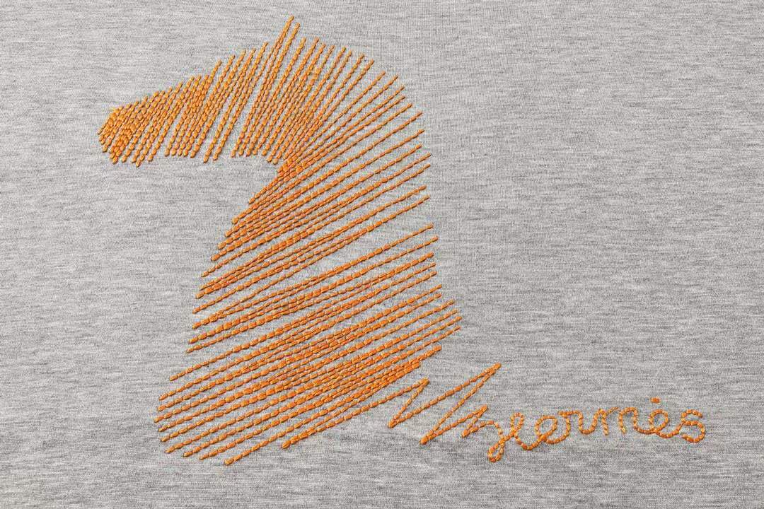 Hermes gray crew neck t-shirt featuring a stylized orange horse logo on the chest