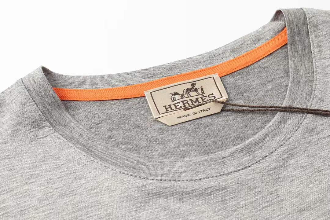 Hermes gray crew neck t-shirt featuring a stylized orange horse logo on the chest