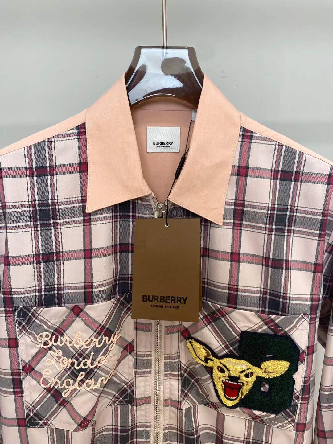 Burberry graphic check varsity overshirt featuring embroidered patches and a zippered front