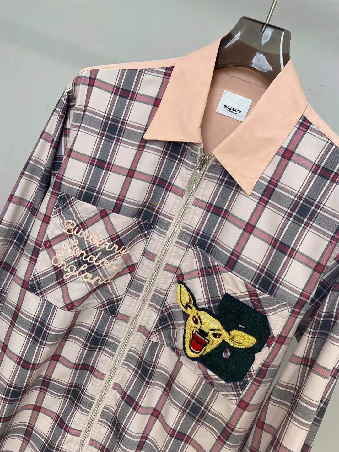 Burberry graphic check varsity overshirt featuring embroidered patches and a zippered front