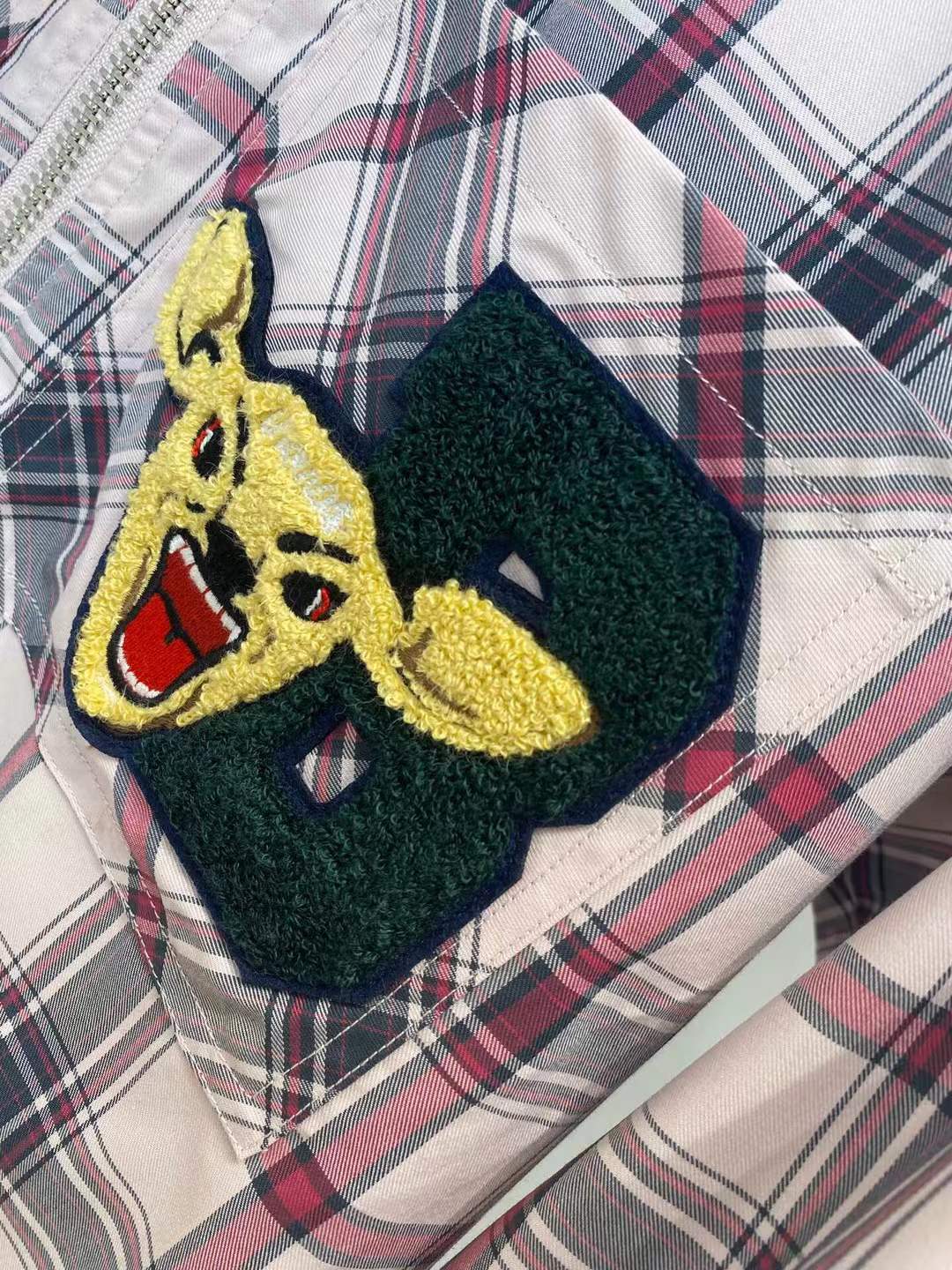 Burberry graphic check varsity overshirt featuring embroidered patches and a zippered front