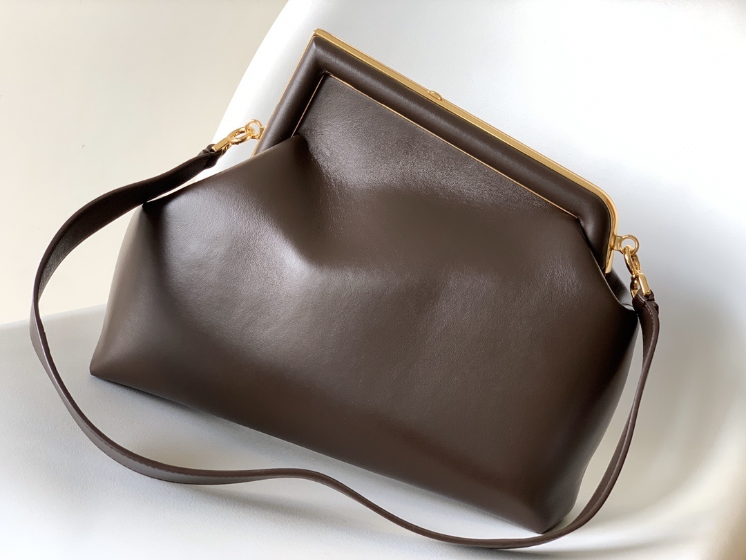 Fendi First Medium Shoulder Bag, which features a distinctive oversized metal 'F' clasp and a detachable shoulder strap