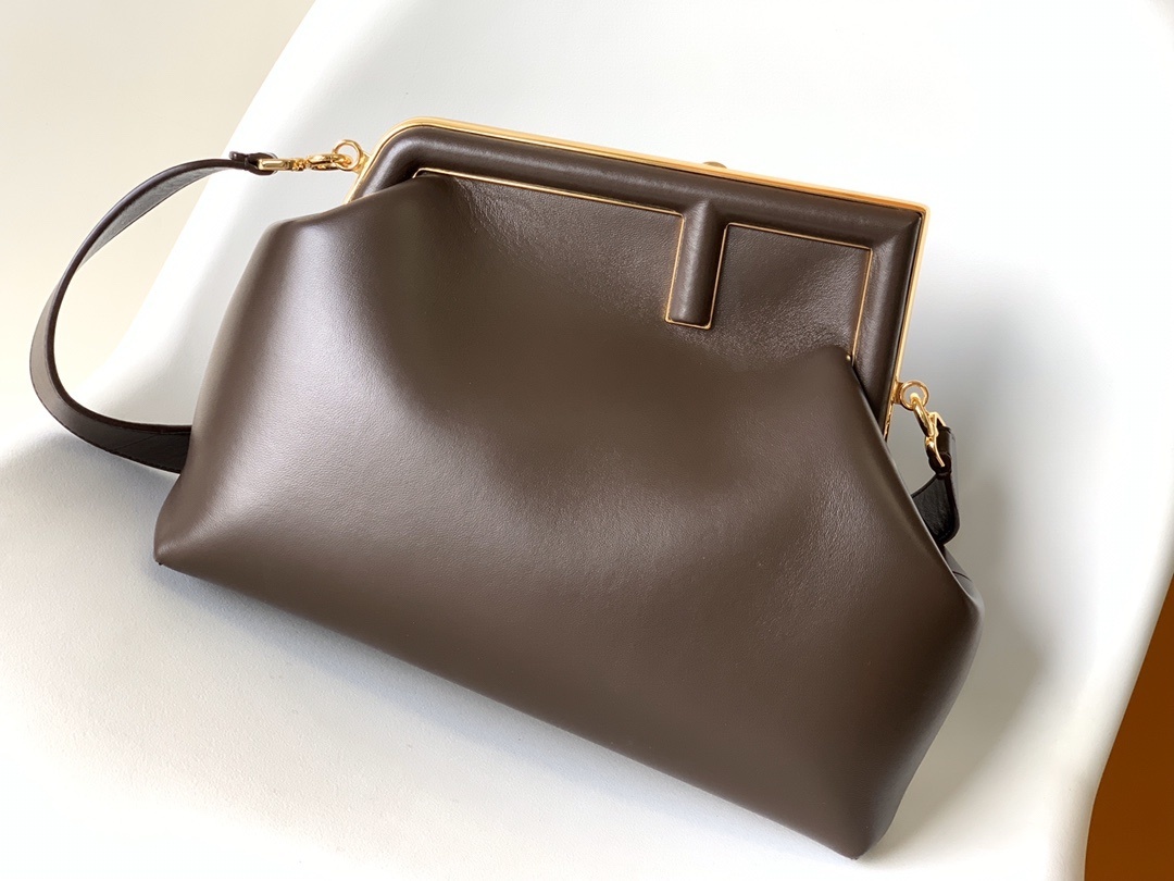Fendi First Medium Shoulder Bag, which features a distinctive oversized metal 'F' clasp and a detachable shoulder strap