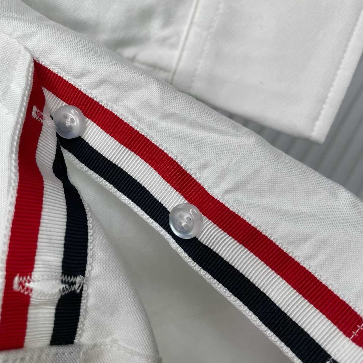 Thom Browne white cotton button-down shirt featuring the signature 4-bar stripe detail on the left sleeve.