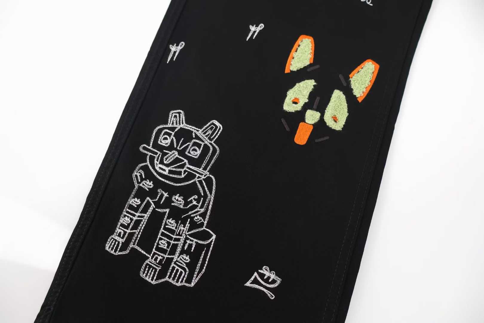 Loewe x Louis Wain embroidered wide-leg jeans in black, featuring playful animal appliqués inspired by the British artist's "Futurist Cats" series