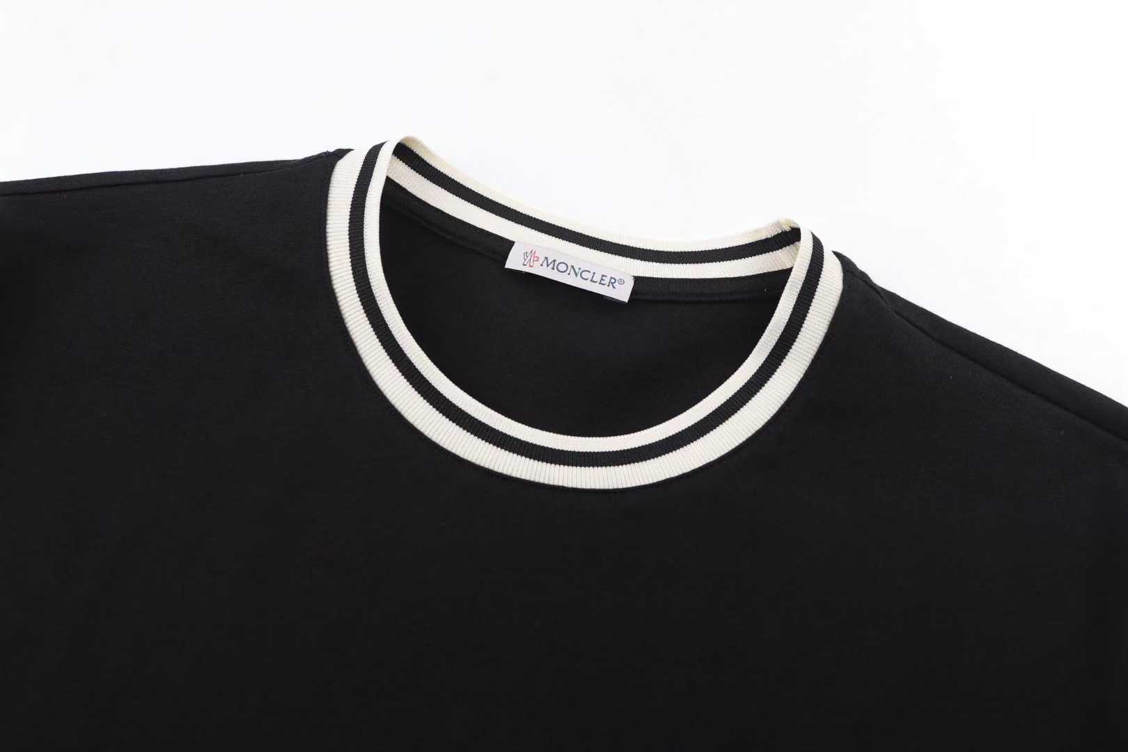 Moncler Striped-Trim Detail-Appliqué T-Shirt is a luxury cotton jersey crewneck featuring a distinctive mascotte logo patch on the chest and striped detailing on the neckline