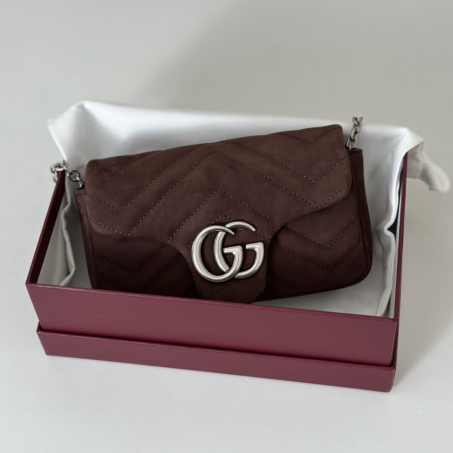 Gucci GG Marmont mini shoulder bag specifically in a brown or burgundy matelassé leather with silver-toned hardware
