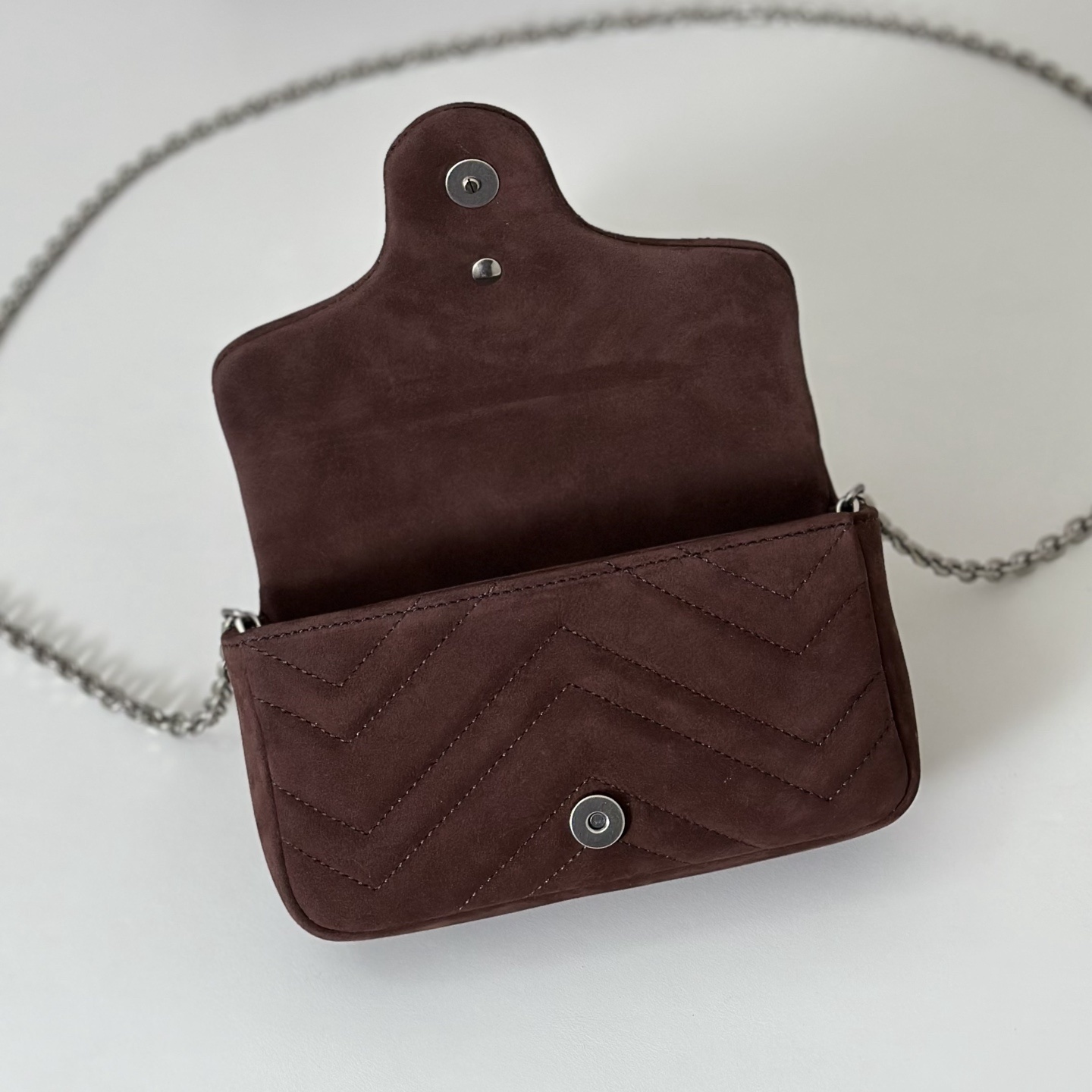 Gucci GG Marmont mini shoulder bag specifically in a brown or burgundy matelassé leather with silver-toned hardware