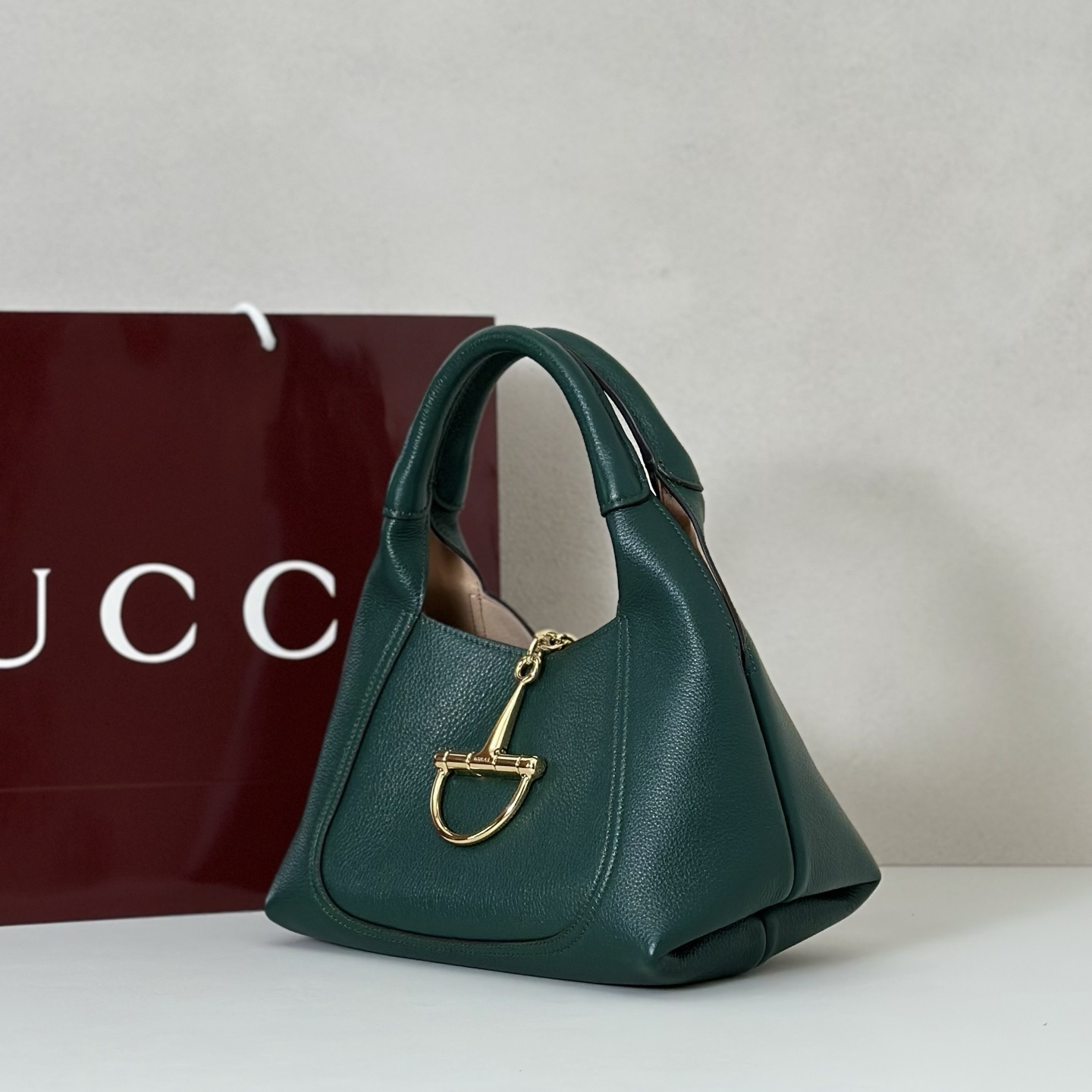 Gucci Softbit shoulder bag is crafted from green textured leather and features gold-toned hardware with a signature oversized half Horsebit