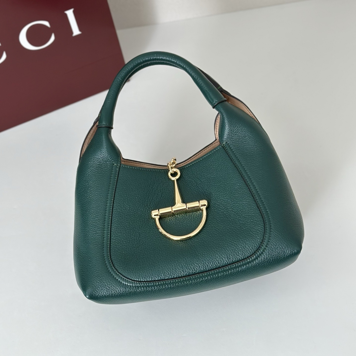 Gucci Softbit shoulder bag is crafted from green textured leather and features gold-toned hardware with a signature oversized half Horsebit