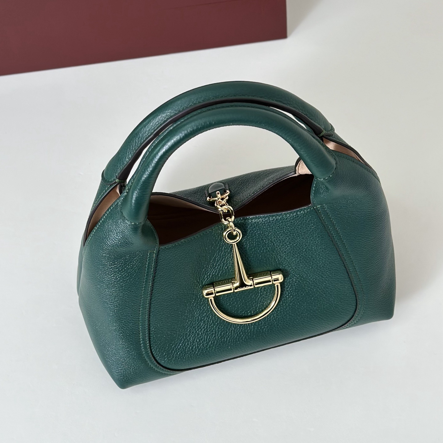 Gucci Softbit shoulder bag is crafted from green textured leather and features gold-toned hardware with a signature oversized half Horsebit