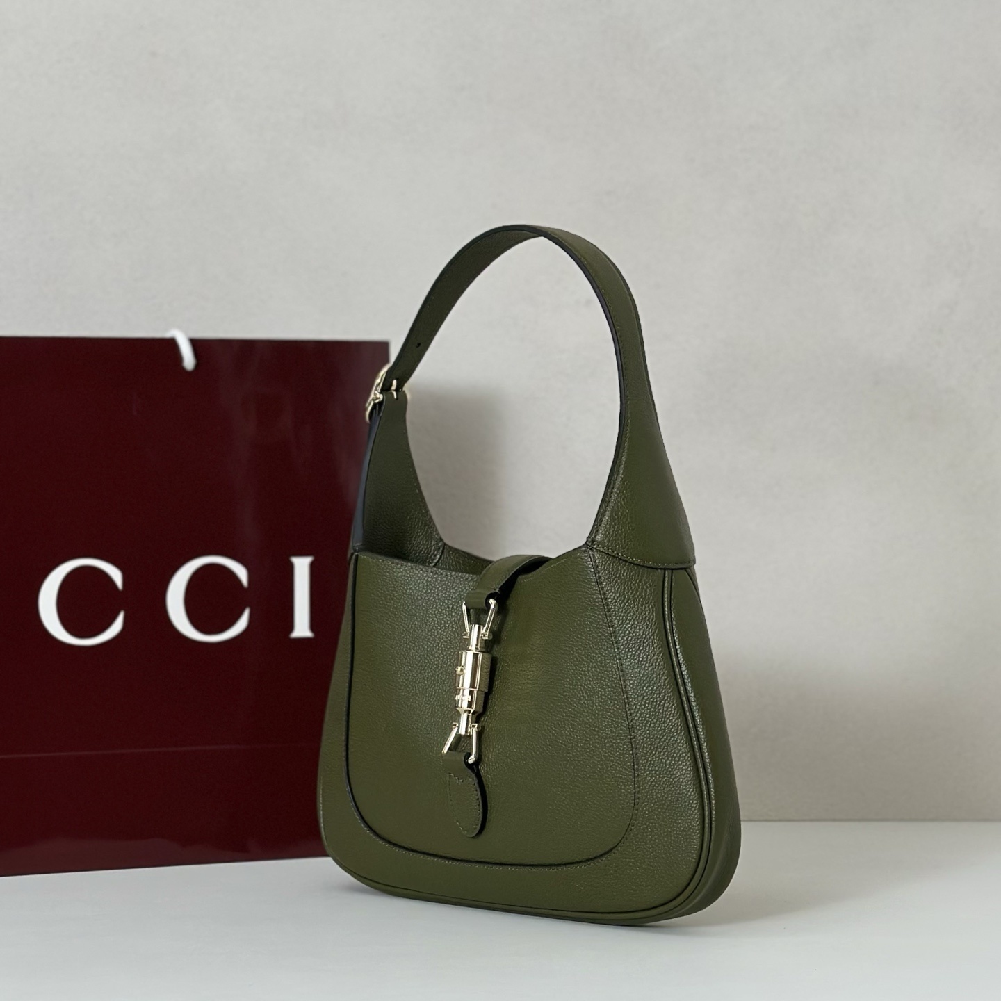 Gucci Jackie 1961 small shoulder bag crafted in textured green leather with a signature piston closure