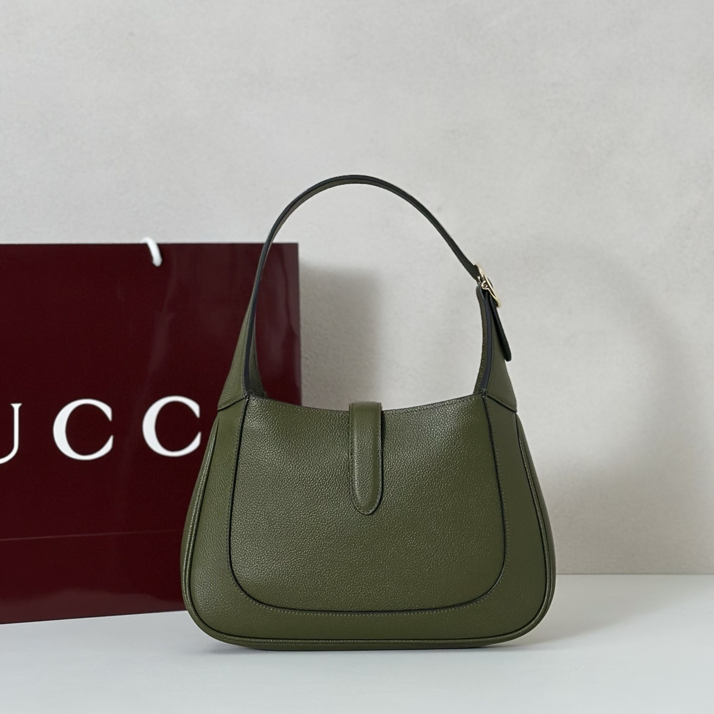 Gucci Jackie 1961 small shoulder bag crafted in textured green leather with a signature piston closure