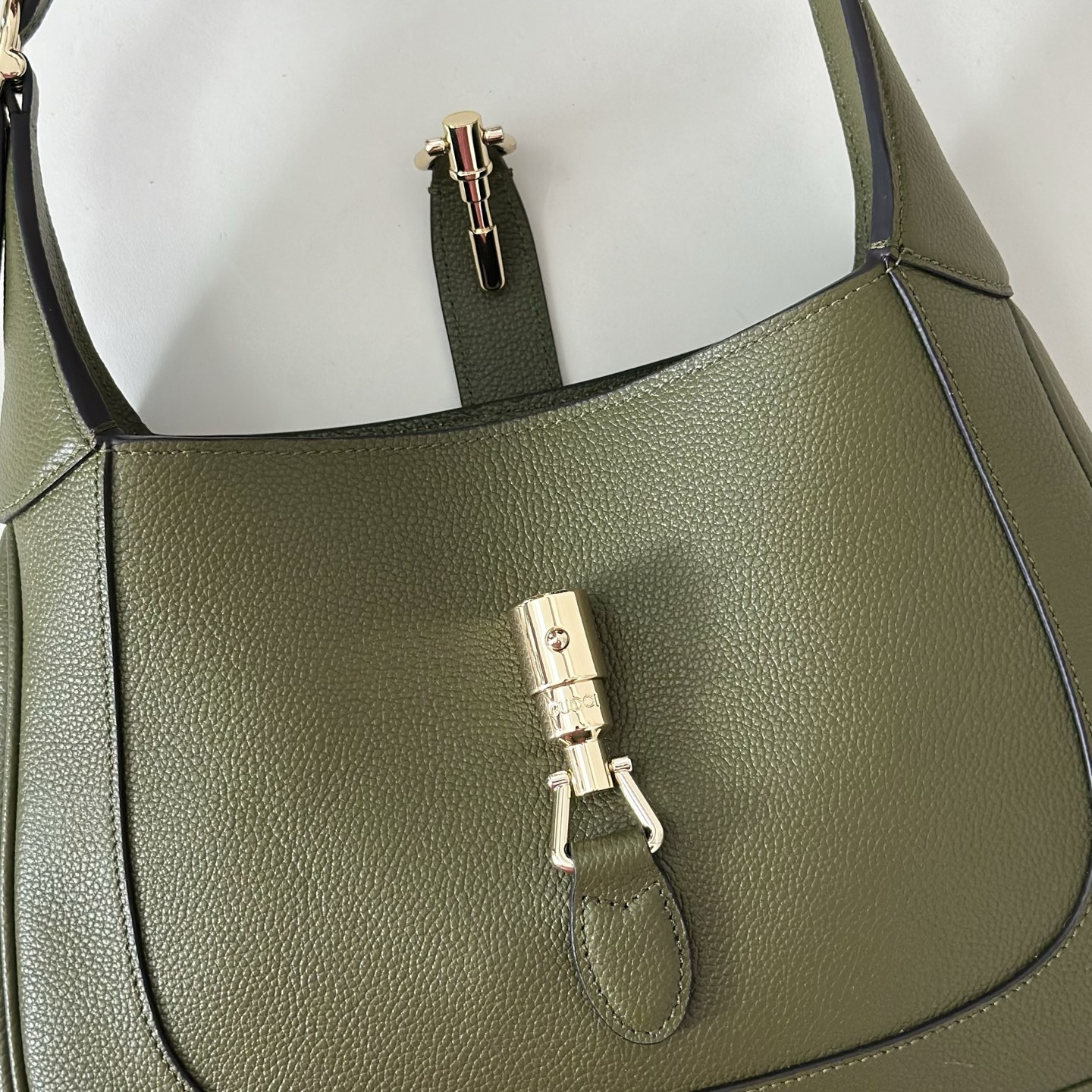 Gucci Jackie 1961 small shoulder bag crafted in textured green leather with a signature piston closure