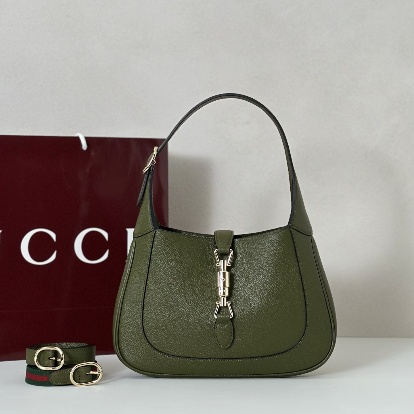 Gucci Jackie 1961 small shoulder bag crafted in textured green leather with a signature piston closure